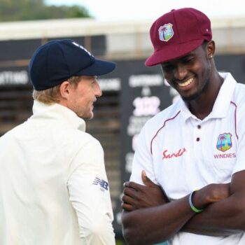 Jason Holder in his West Indies Test Cricket Cap talking to Joe Root.