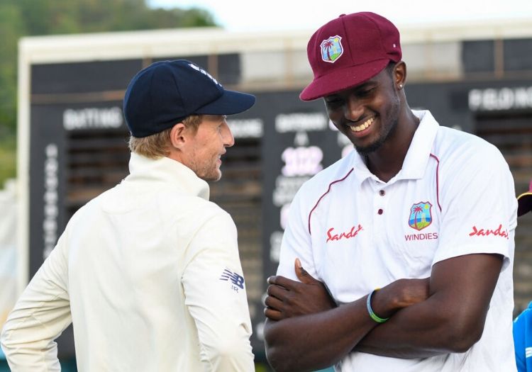 Jason Holder in his West Indies Test Cricket Cap talking to Joe Root.