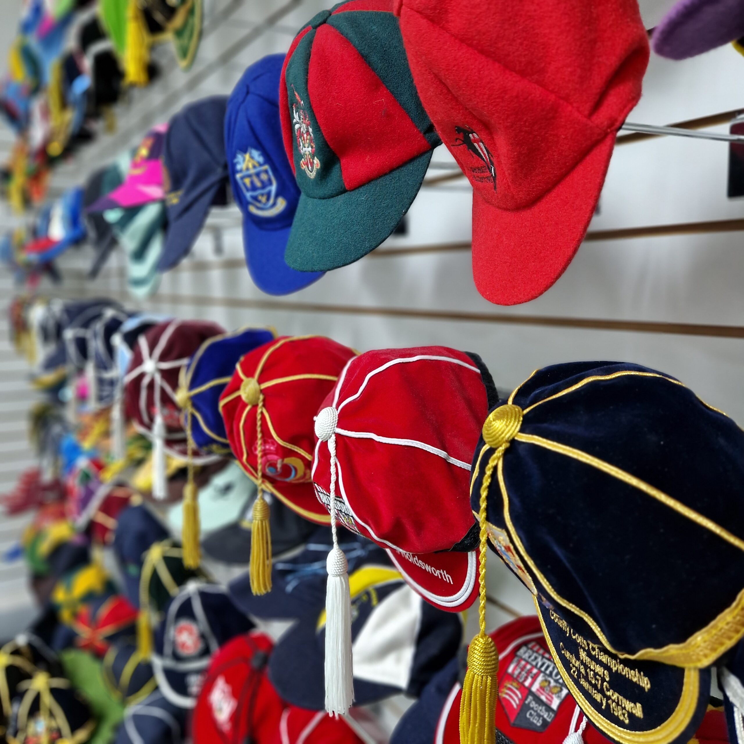3 rows of honour caps that are hung on a wall for display at Gentlemen and Players shop in High Wycombe
