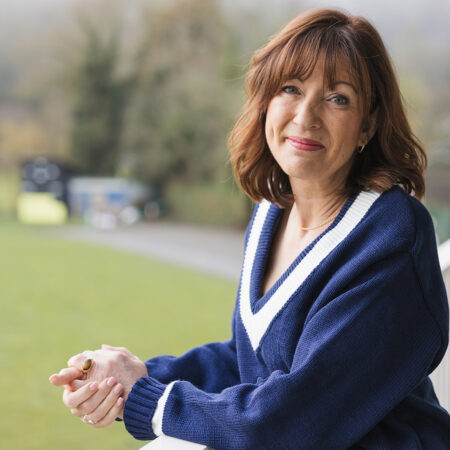 woman on balcony wearing a traditional sweater.